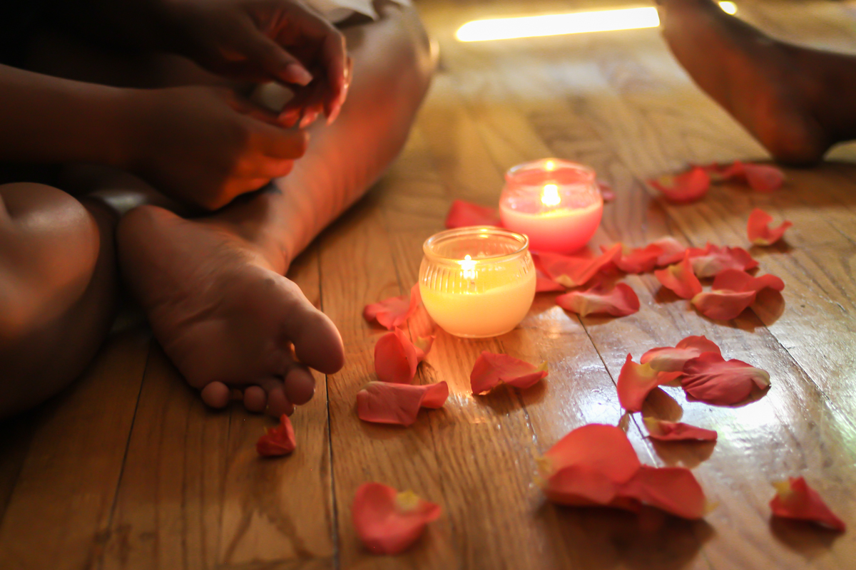 Candlelight, rose petals and bare feet on warm wood