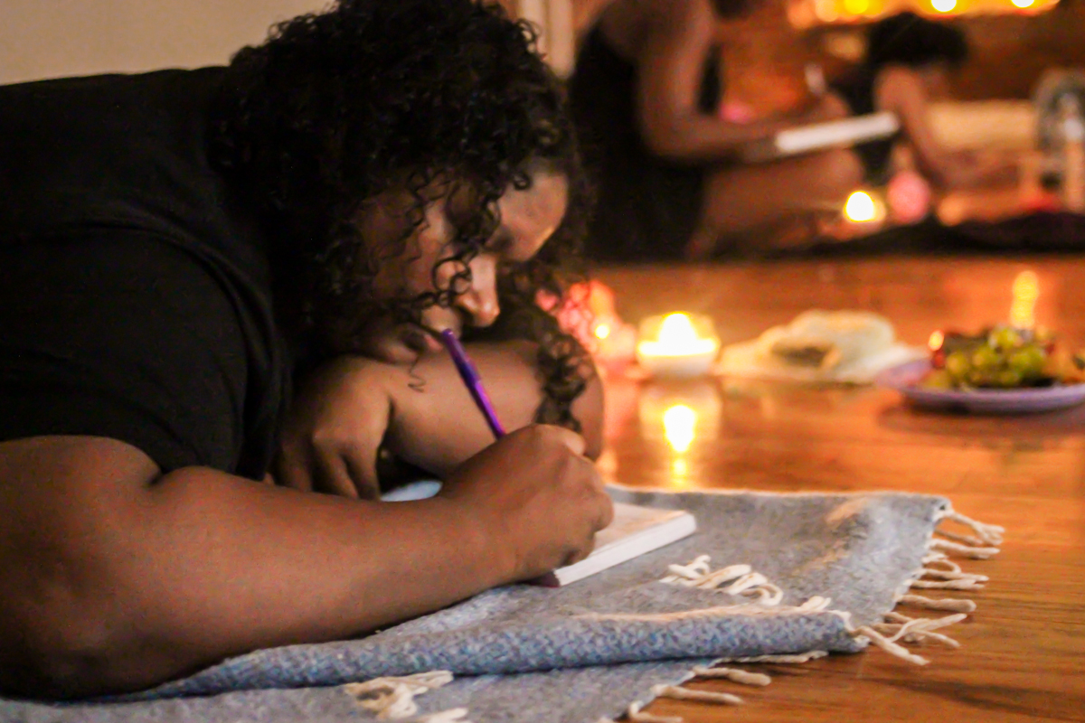 A participant journaling by candlelight