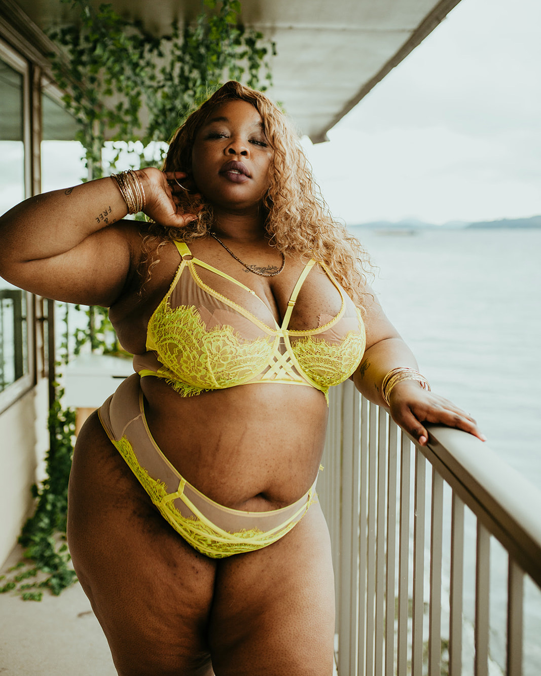 Rashida KhanBey Miller in chartreuse lace on a balcony overlooking water