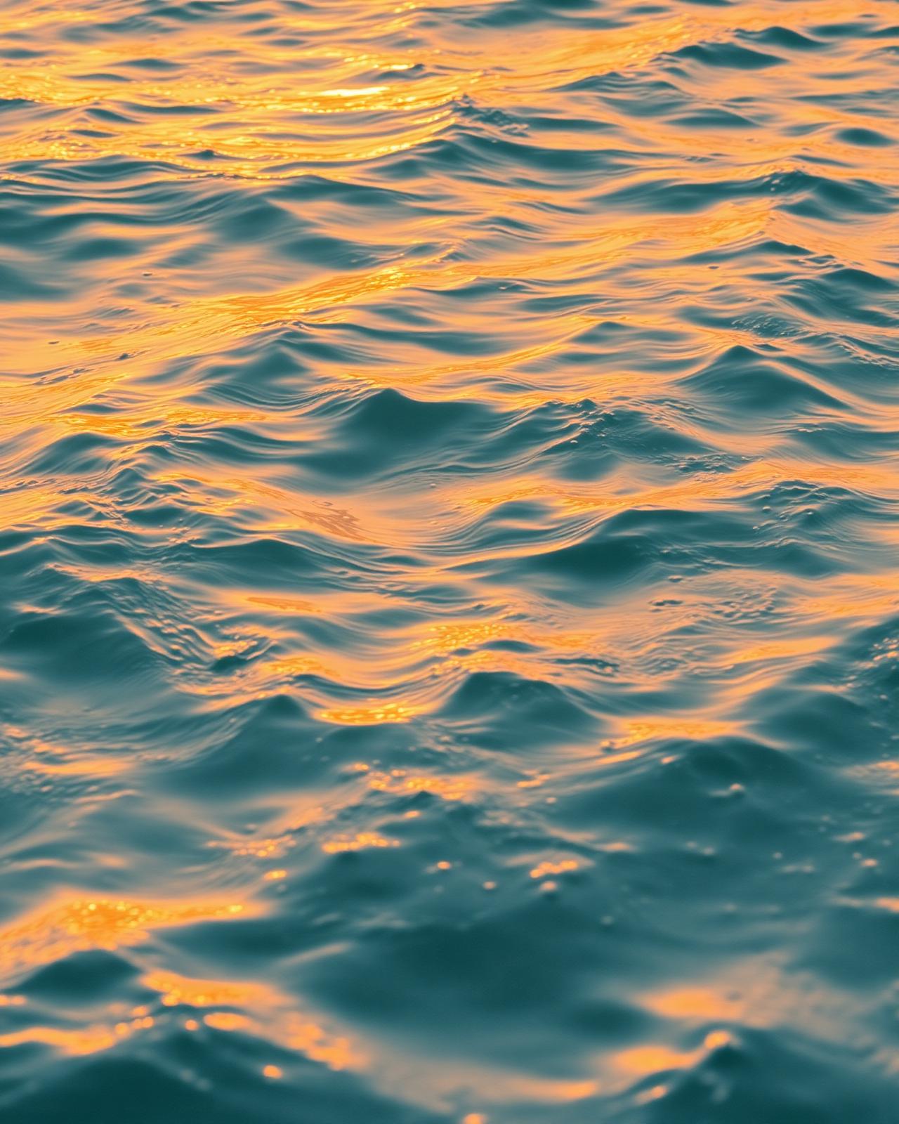 Sunlit ocean ripples in golden hour light